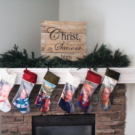 custom photo stockings hanging from a fireplace mantle.
