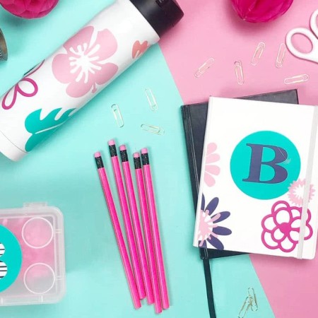 pink and teal vinyl decals made with the cricut maker to label back to school supplies.