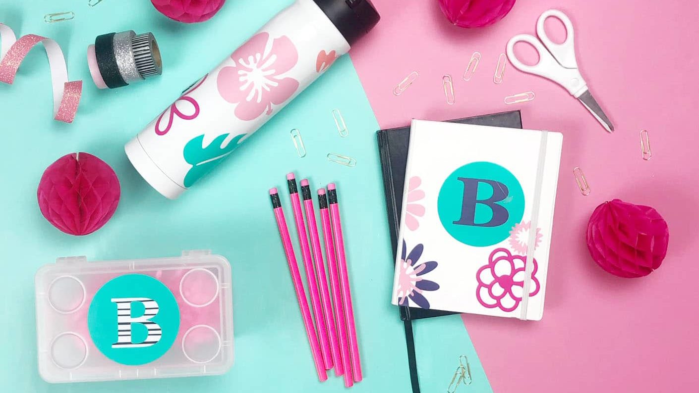 pink and teal vinyl decals made with the cricut maker to label back to school supplies.