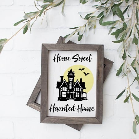 wood sign with a haunted house