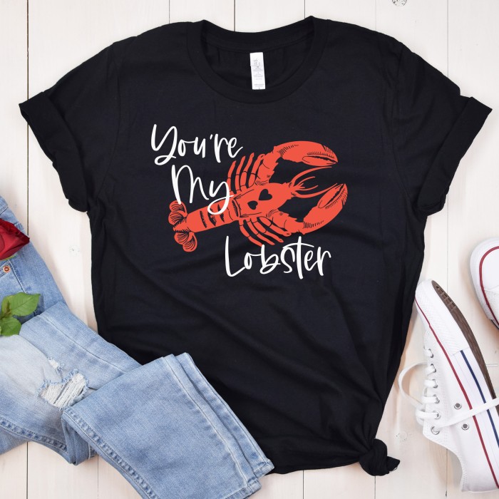 Flatlay of a black shirt with jeans and converse shoes. Shirt has a red lobster with the text "You're My Lobster" on it.