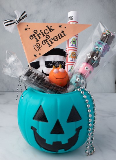 Pumpkin bucket filled with treats, games, and decorations