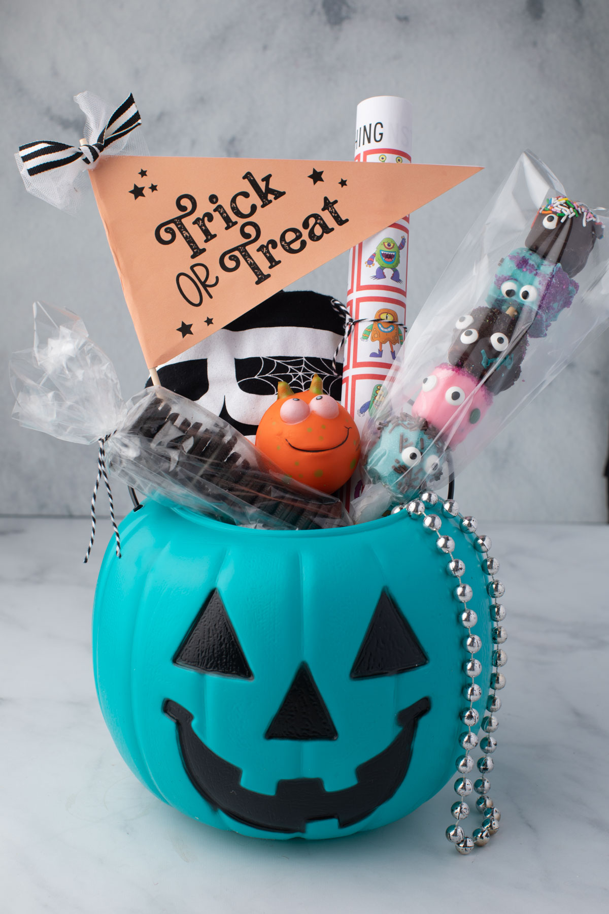 Pumpkin bucket filled with treats, games, and decorations