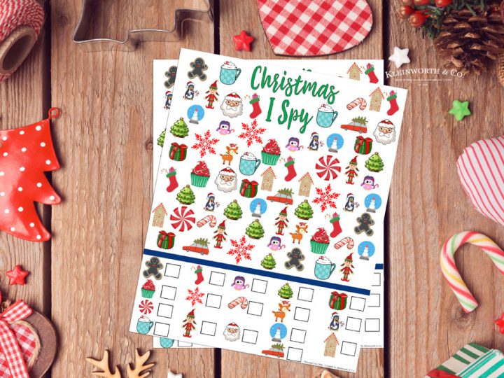 a christmas ispy game printed on paper, placed on a wood background. Christmas decorations are placed around.