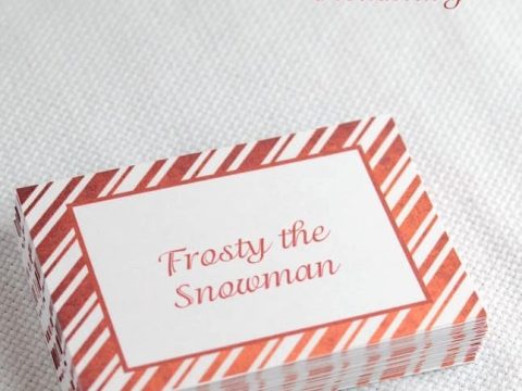 a stack of cards with christmas songs listed on them, meant to play christmas song pictionary