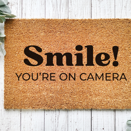 custom door mat with the words Smile you're on camera
