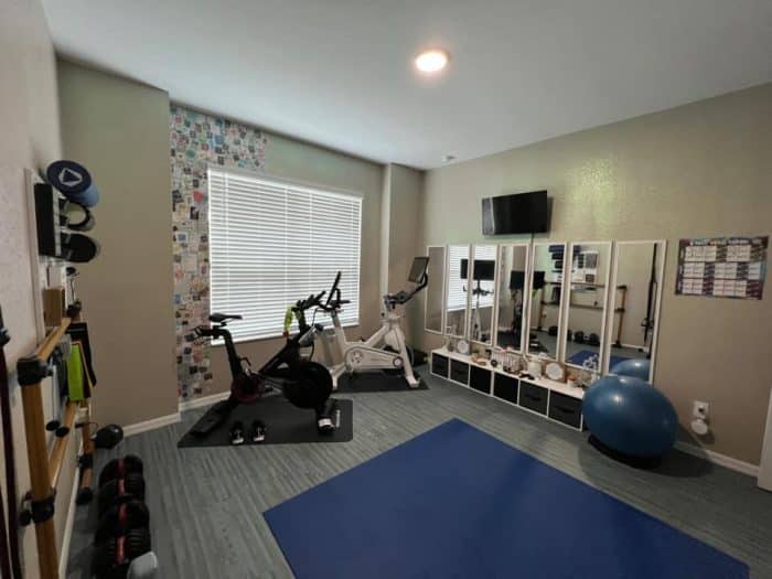 a home gym with many vertical mirrors 