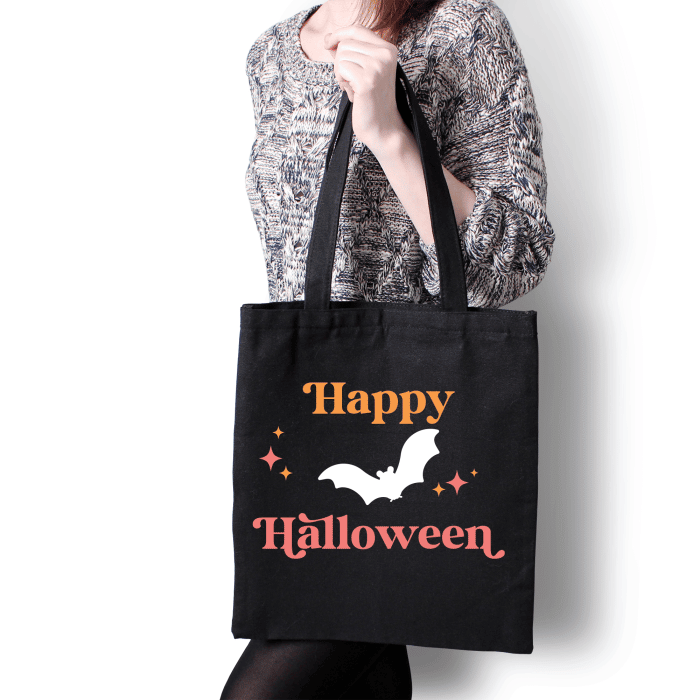 black tote bag with design of bat and happy halloween and midcentury style stars.
