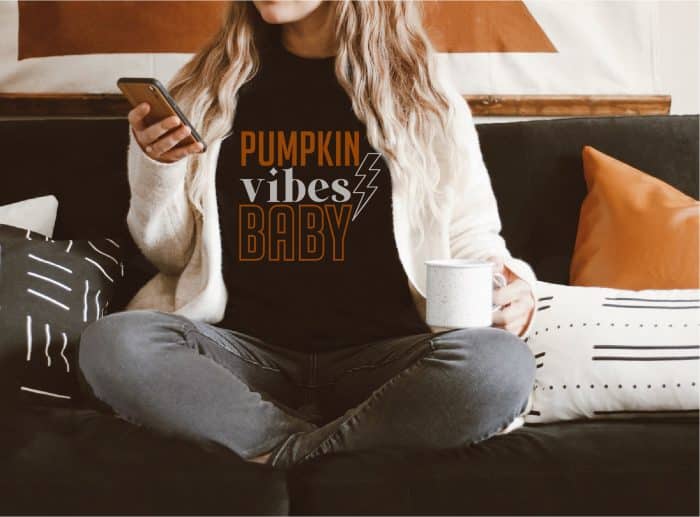 woman with black shirt that says pumpkin vibes baby