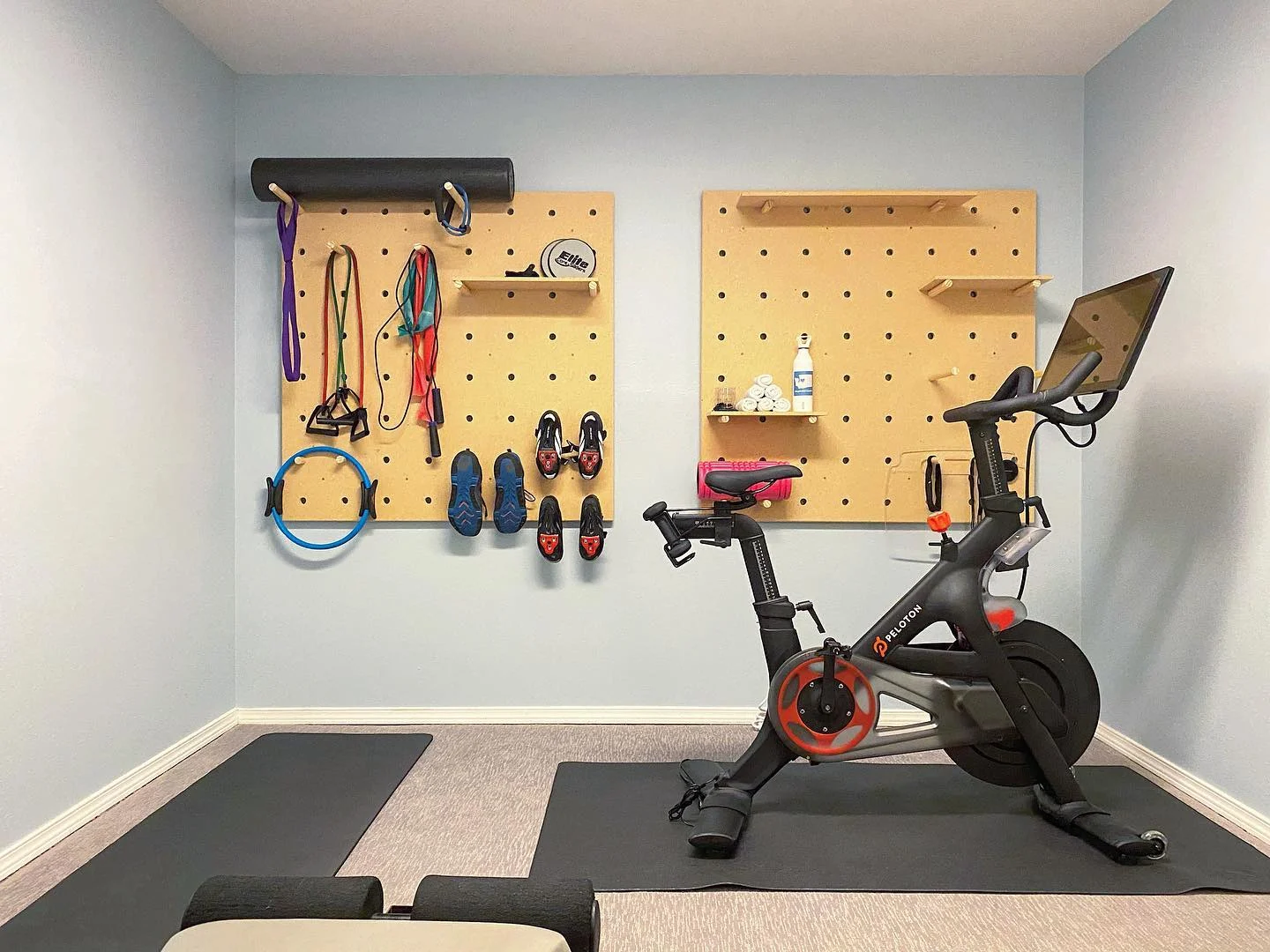 small pelolton room with wall storage for workout equipment