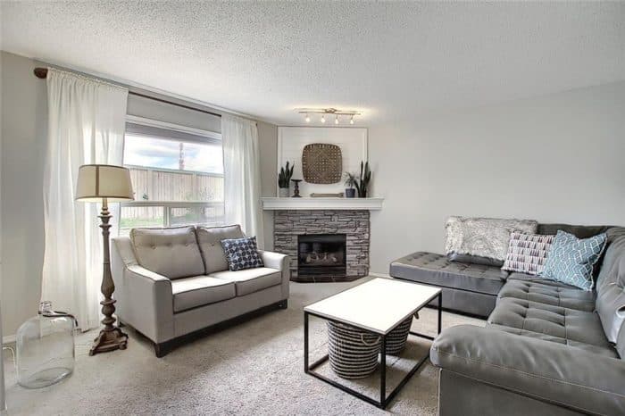 Stone corner fireplace with whitewashed stone and shiplap to fill in the awkward space above the TV. 