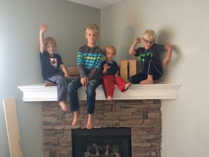 Stone corner fireplace with faux stone decorated with wooden pallets.