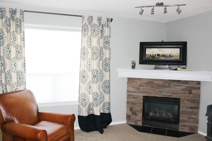 A corner fireplace with stone and an awkward space above.