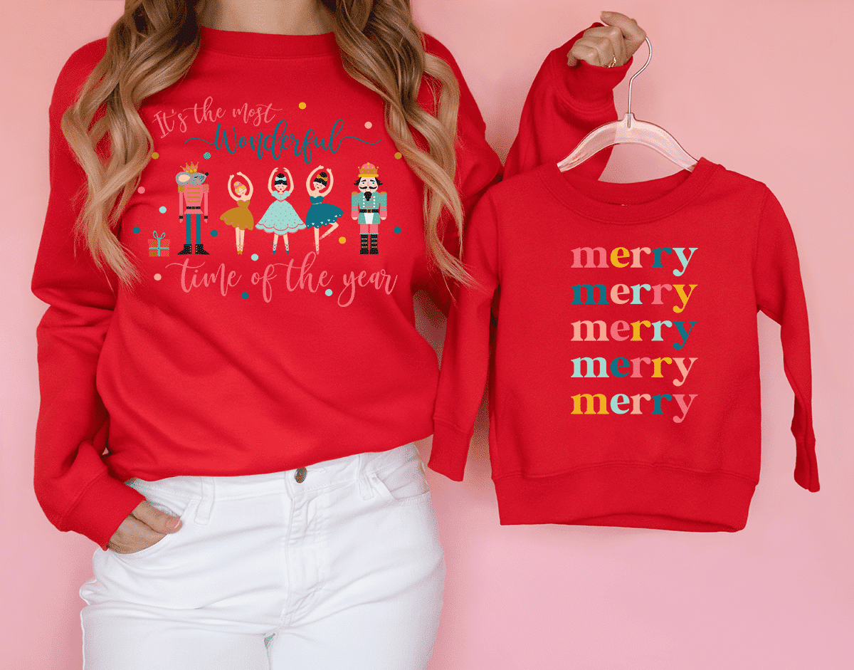 girl wearing red sweater with a nutcracker christmas design on it. In her hands is a childs sweatshirt with a coordinating design.