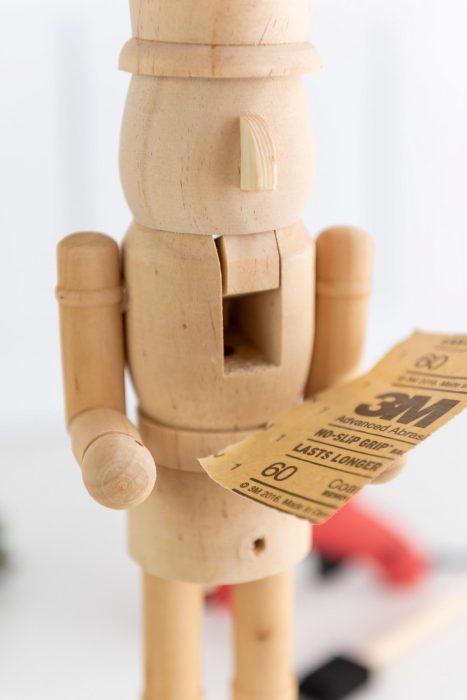 unfinished nutcracker holding sandpaper