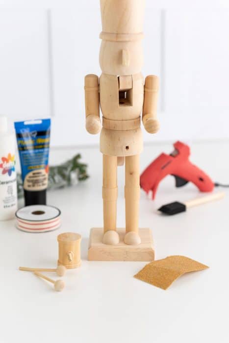 unfinished wooden nutcracker and craft supplies to make a DIY modern nutcracker