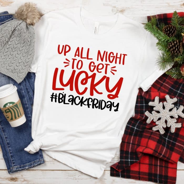 a womens white tshirt with a red plaid scarf, denim pants, a starbucks coffee cup, winter hat, and snowflake ornament.