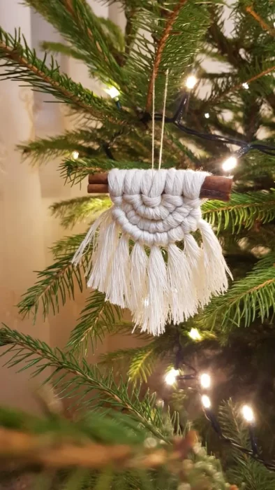 Macrame christmas ornament on a cinnamon stick.
