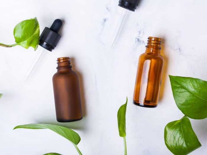 Glass bottles for natural cosmetics on a white marble background