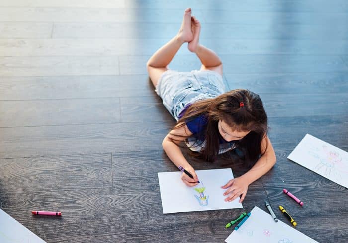 Shes living a life full of color. Full length shot of a young girl lying down on the floor and coloring in pictures in her coloring book at home