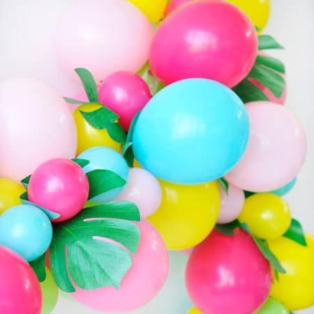 balloon arch with faux palm leaves