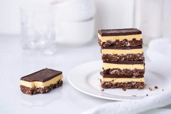 A stack of Nanaimo bars - a traditional Canadian dessert - in a white kitchen.