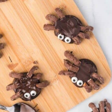 Cute spider cookies for halloween made from oreos dipped in chocolate and pretzels.